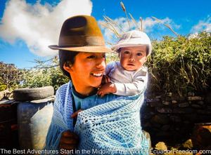 indigenous woman of the quilotoa loop in ecuador with baby smiling at motorcyclist