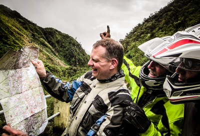 motorcyclists lost in ecuador looking at a map upside down