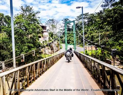 riding motorcycle across metal bridge in puerto misahualli ecuador
