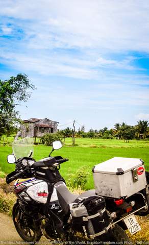 Adventure motorcycle parked next to rice field in ecuador coastal region