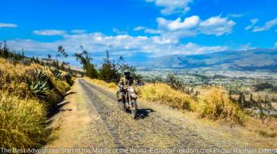 riding a dual sport motorcycle on a cobblestone road in Ecuador