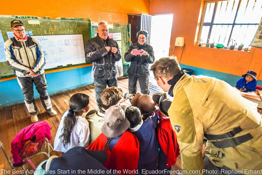 motorcycle tour participants visiting a rural schoolhouse in Ecuador