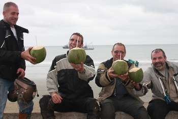 motorcyclists drinkng coconut on beach in ecuador