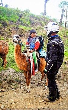 talkiung to a boy on a llama ecuador motorcycle adventure toru